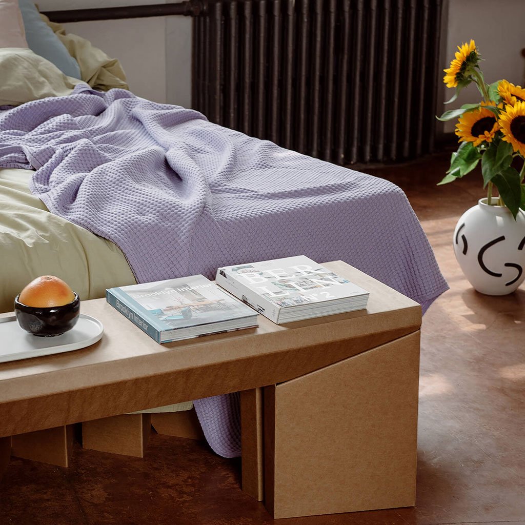 ROOM IN A BOX - Sitzbank aus Wellpappe vor dem Bett